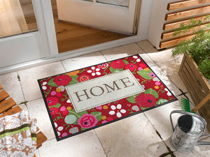 Bild in Slideshow öffnen, Fußmatte mit Rosen und Schriftzug &quot;HOME&quot; vor der Tür
